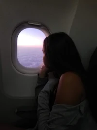 a woman looking out the window of an airplane