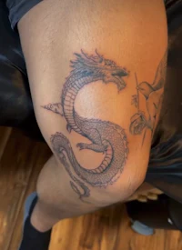 a tattoo of a dragon on a man's knee