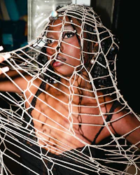 a woman in a black dress covered in netting