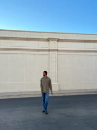 a man standing in front of a white wall