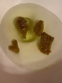 olive oil in a bowl with a few pieces of olives in it