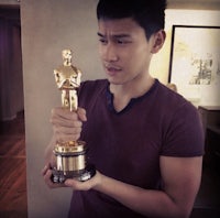 a man holding an oscar trophy in his hand