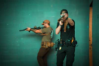 two men with guns in a room