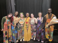 a group of people posing for a photo on stage