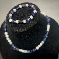 a necklace with blue and white beads on a mannequin