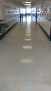 a school hallway with a white floor and a lot of lockers
