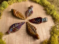 a group of leaf shaped beads on a wooden board