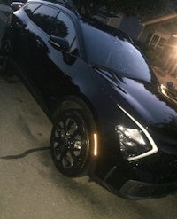 a black suv parked in a driveway at night