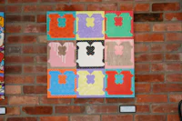 a piece of art hanging on a brick wall