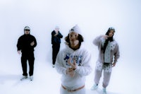 a group of people standing in front of a white background
