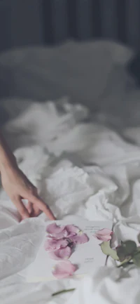 a woman is laying on a bed with flowers on it