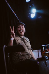 a man sitting in a chair and making a peace sign
