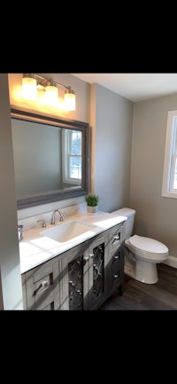 a bathroom with a sink, toilet and mirror