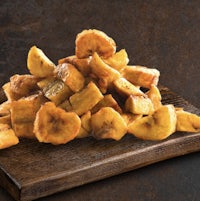 fried banana slices on a wooden cutting board
