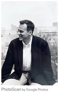 a man in a suit sitting on a ledge