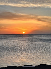 an image of the sun setting over the ocean