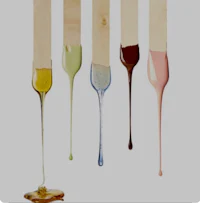 five different colors of liquid are dripping from sticks
