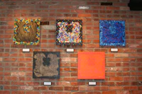 a group of paintings on a brick wall