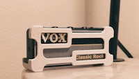 the vox classic rock is sitting on a table next to a lamp