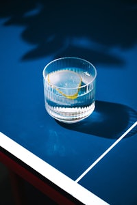 a glass of water on top of a ping pong table