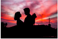 a silhouette of a couple at sunset