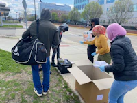 a group of people standing next to a box on a sidewalk