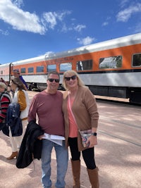 two people standing in front of a train