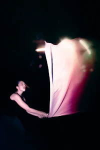 a woman holding a white cloth in the dark