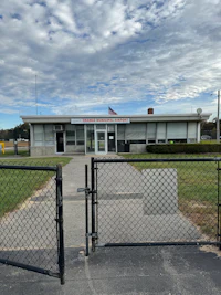 the front of a building with a chain link fence