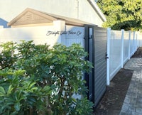 a white fence with a black gate in front of it