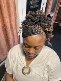 a woman with dreadlocks sitting in a chair