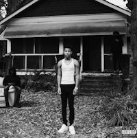a young man standing in front of a house