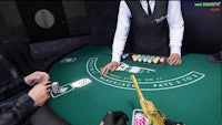a man in a suit is playing a game of blackjack