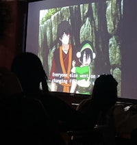 a group of people watching anime on a screen