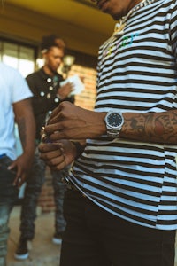a group of men with tattoos and a watch