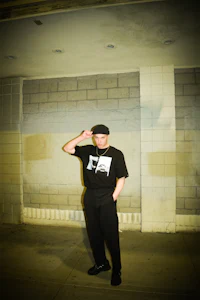 a man wearing a black hat and black pants