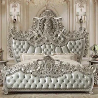 an ornate silver bed with ornate headboard and footboard