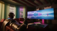 a man is sitting in a living room watching a tv