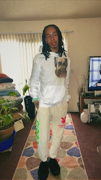 a man with dreadlocks standing in a living room