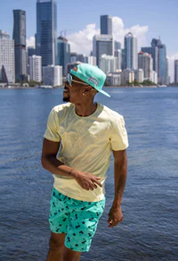a man wearing a hat and shorts in front of a city skyline