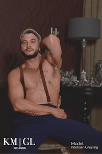 a man in suspenders posing in a room