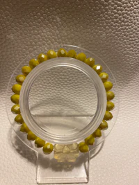 a yellow glass bead holder on a white surface