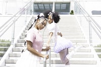 two girls standing on the steps of a building