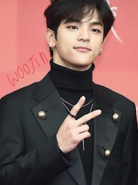 a young man in a black suit posing for the camera