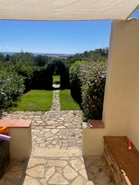 a stone pathway leading to a patio with a view of the sea