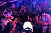 a group of people standing in a circle at a nightclub