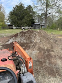 a bulldozer is being used to dig a hole in a yard