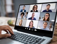 a person is using a laptop with a group of people on it