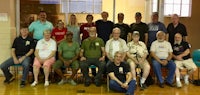 a group of people posing for a photo in a gym