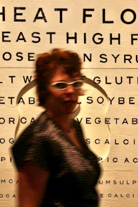 a woman walking past an eye chart